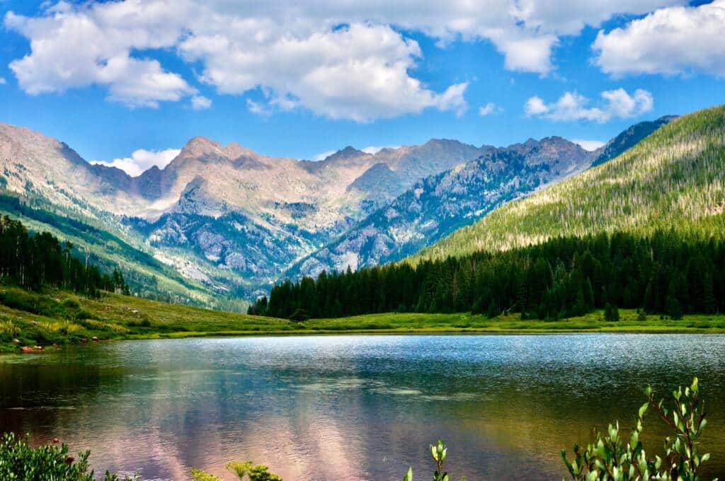 Alpine lake below snow-capped mountains