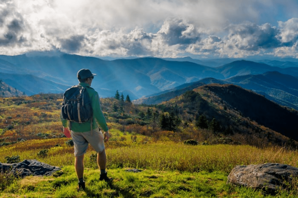 Hiker looking out over layered mountain ridges