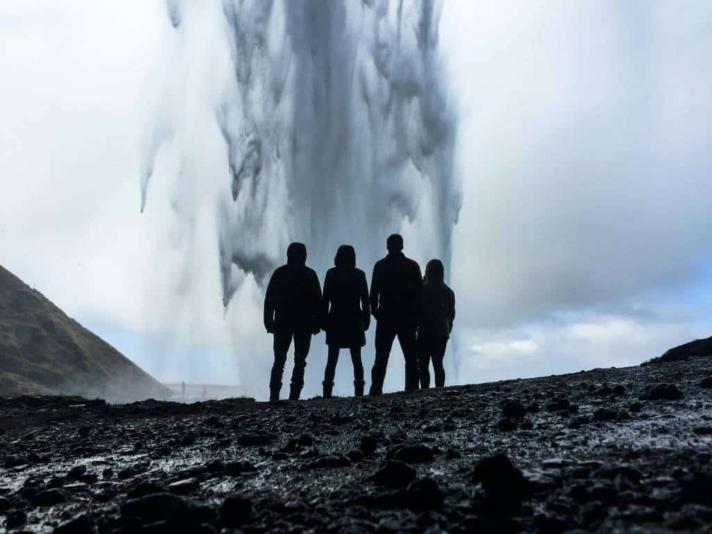 Group silhouetted in front of a waterfall