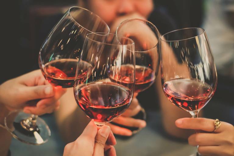 Friends raising glasses of red wine