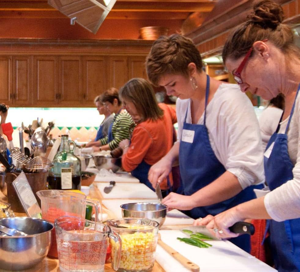 Team chopping vegetables together at a hands-on cooking class