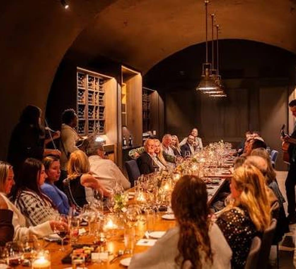 Candlelit team dinner at a long table inside a Napa Valley wine cave