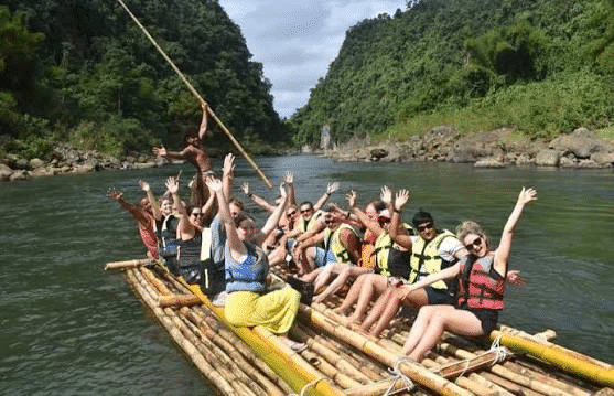 Team riding a bamboo bilibili raft down the Navua River gorge