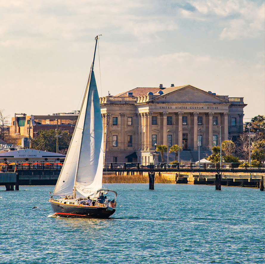 Sailboat passing a waterfront building in Charleston