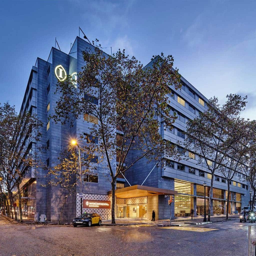 InterContinental Barcelona at dusk on a tree-lined avenue near Montjuïc