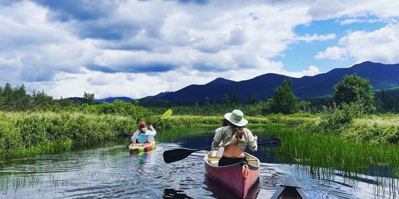 Team canoeing and kayaking through an Adirondack marsh